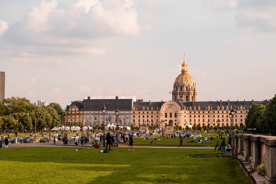 Beautiful view of Les Invalides and surrounding park with people relaxing in Paris, France.