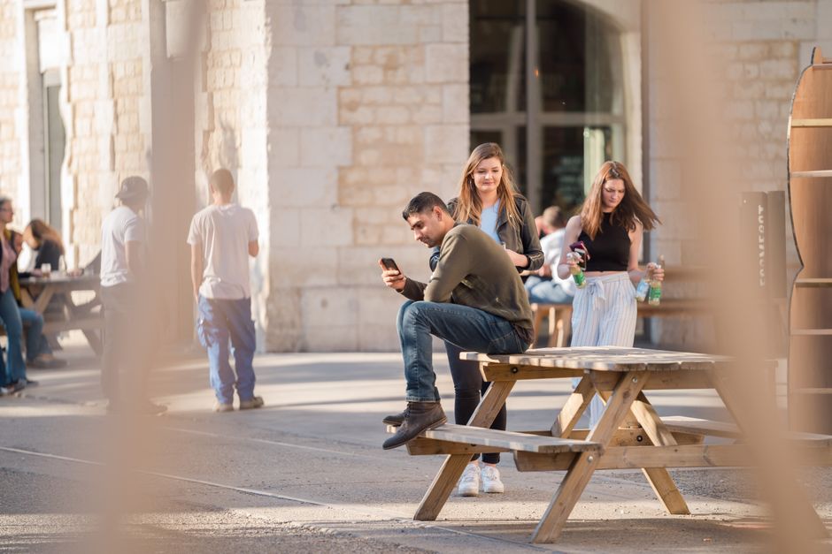 Group of friends enjoying leisure time at an outdoor cafe in Bordeaux.