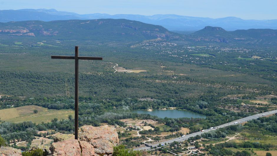 Majestic view from Les Trois Croix in Roquebrune-sur-Argens overlooking lush valley and distant mountains.