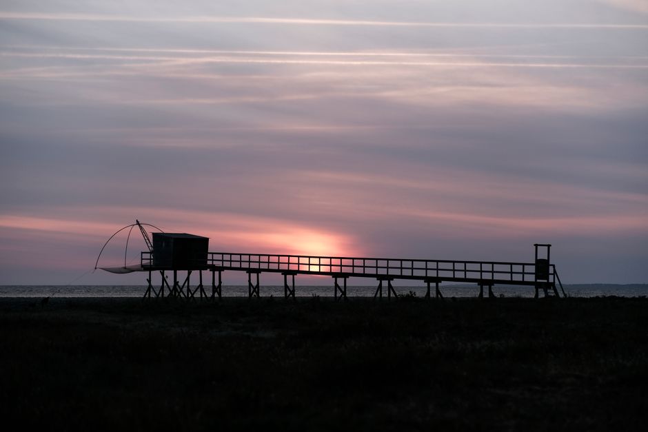 Beautiful sunset over a fishing pier in Les Moutiers-en-Retz, France.