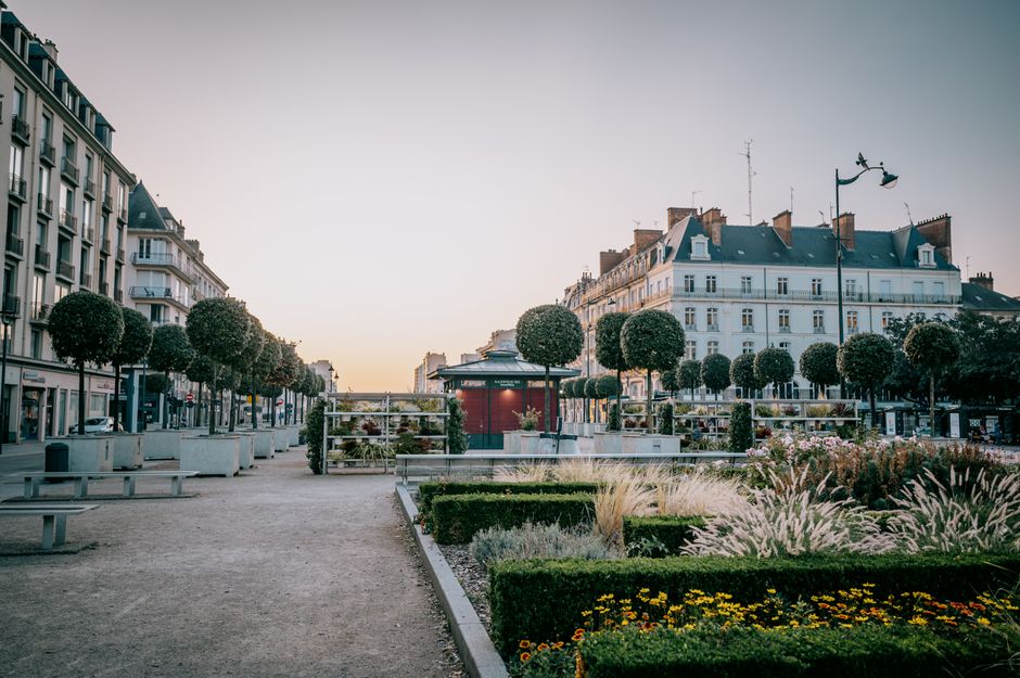 Peaceful city square in Rennes, France with beautiful architecture and greenery at sunset.
