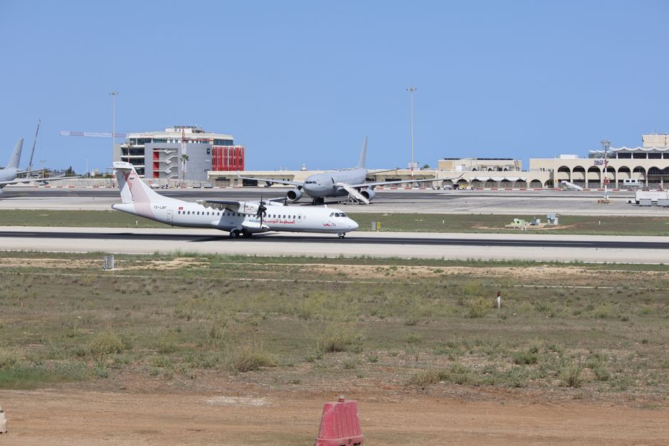 A commercial airplane preparing for takeoff on a sunny day at the airport.