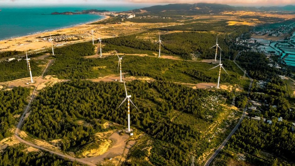 A scenic aerial shot of wind turbines along the Vietnam coastline, showcasing renewable energy.