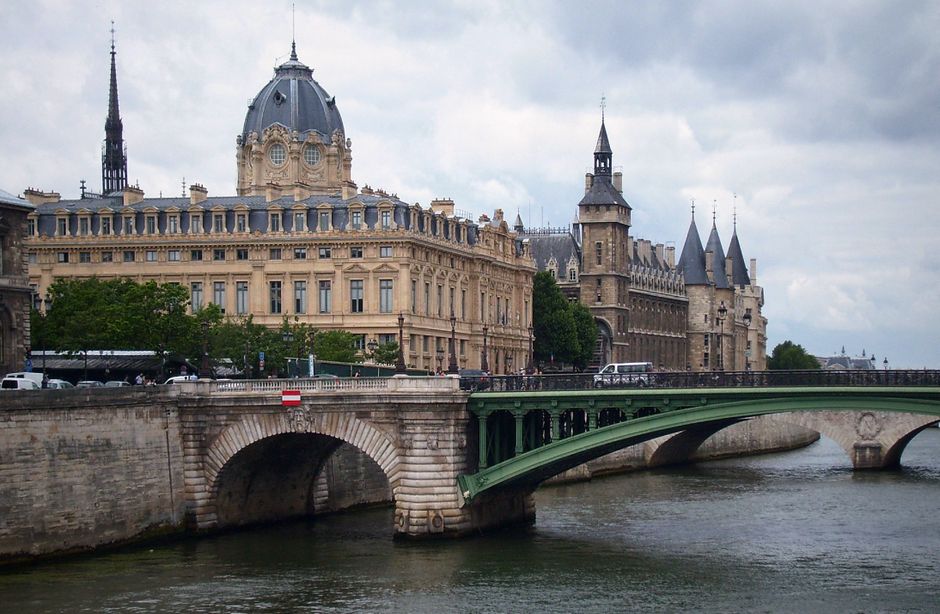 View of grand Parisian buildings and bridge over the Seine River. Iconic French architecture.