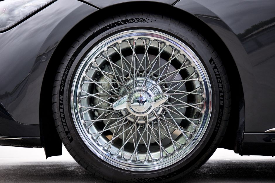 Detailed view of a shiny spoked wheel on a luxury vehicle.