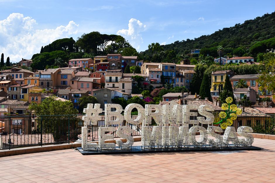 Charming hillside view of Bormes-les-Mimosas village with colorful houses in France.