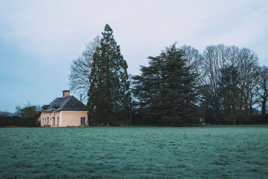 Serene countryside scene with house and trees in Rennes, France.