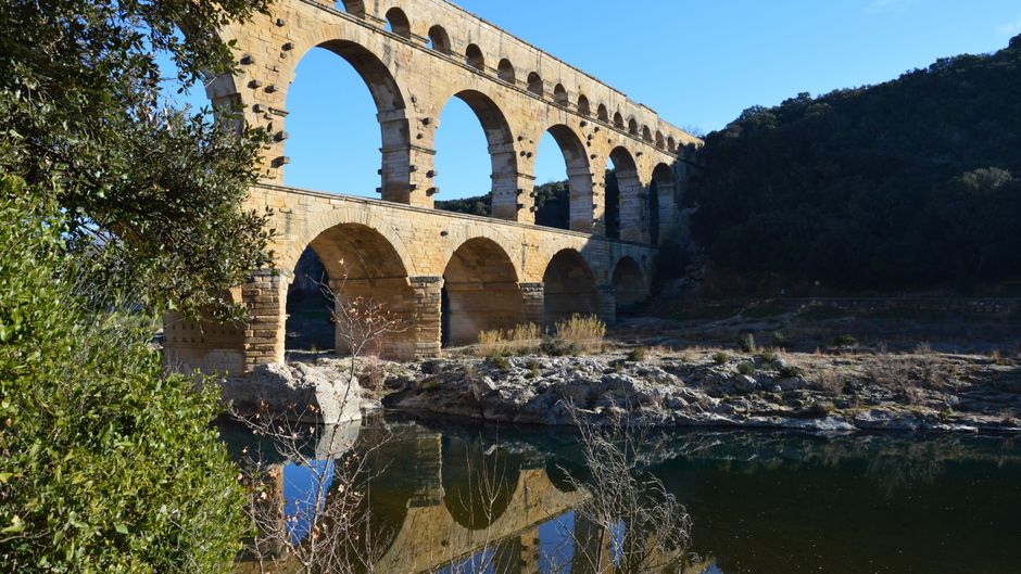 The ancient Roman aqueduct Pont du Gard stands tall over the Gardon River in Occitanie, France.