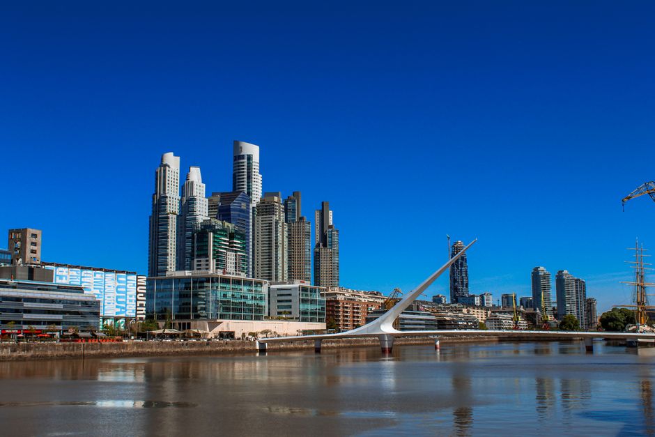 Striking skyline view of Buenos Aires with Puente de la Mujer and modern high-rise buildings on a sunny day.