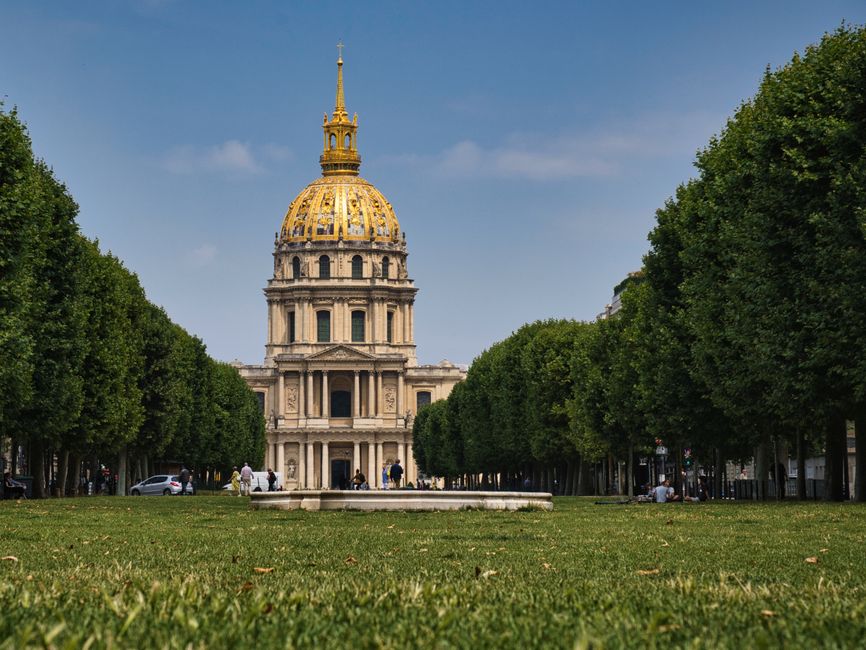 Stunning view of Les Invalides dome in Paris, surrounded by greenery under a clear sky.