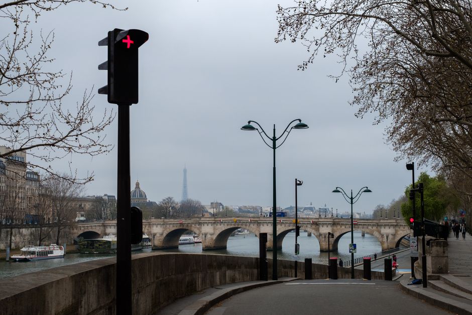 Traffic light and Eiffel Tower view on a cloudy day in Paris, France.