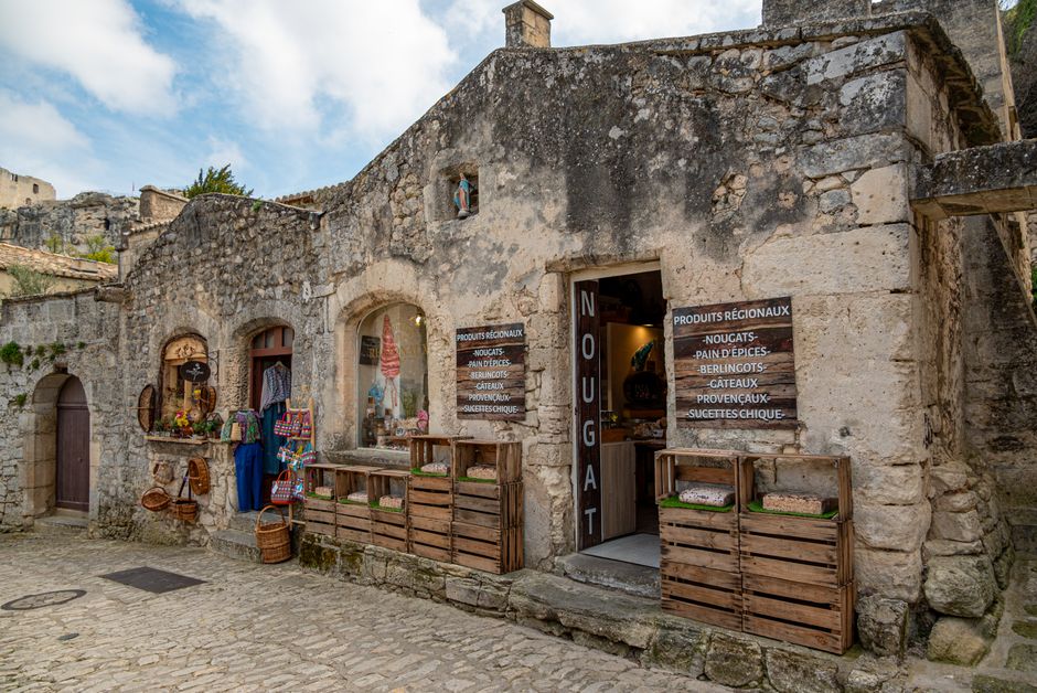 Rustic stone shop facade with regional products in Les Baux-de-Provence, France's Provence region.