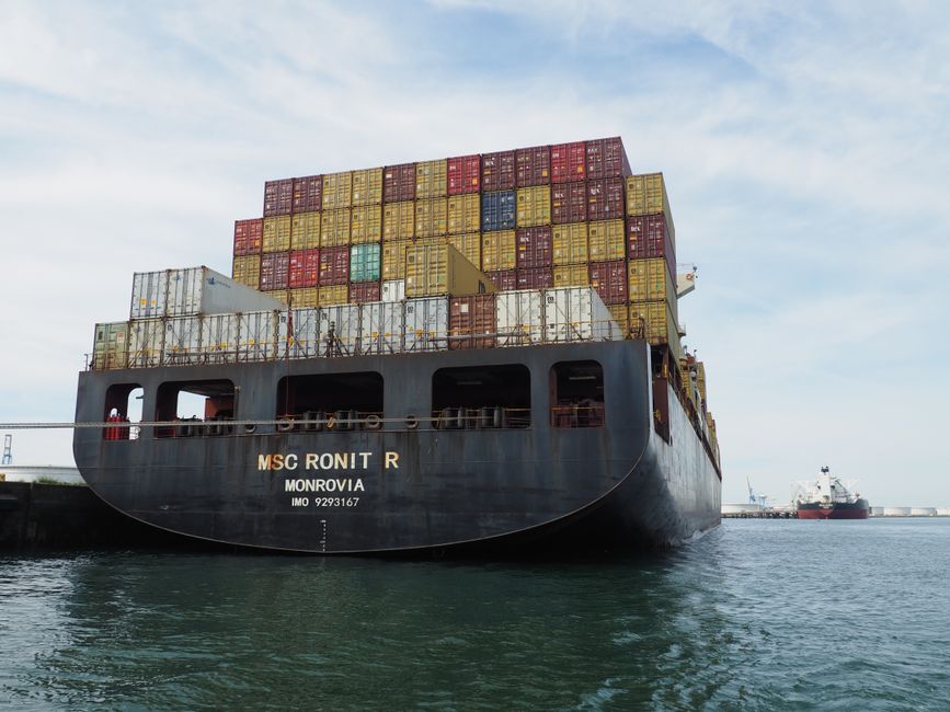 A large cargo ship loaded with colorful containers docked at Le Havre, France.