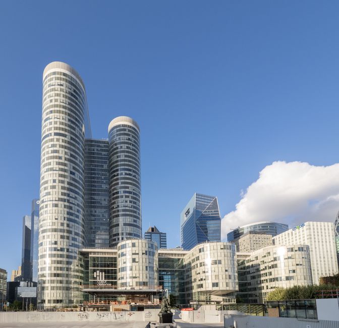 A stunning view of the modern skyscrapers in La Défense, Paris against a clear blue sky.