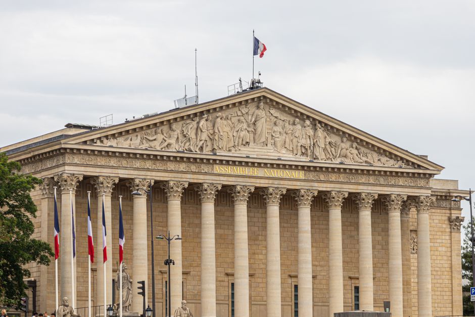 The majestic facade of the Assemblee Nationale in Paris, showcasing classic architecture.