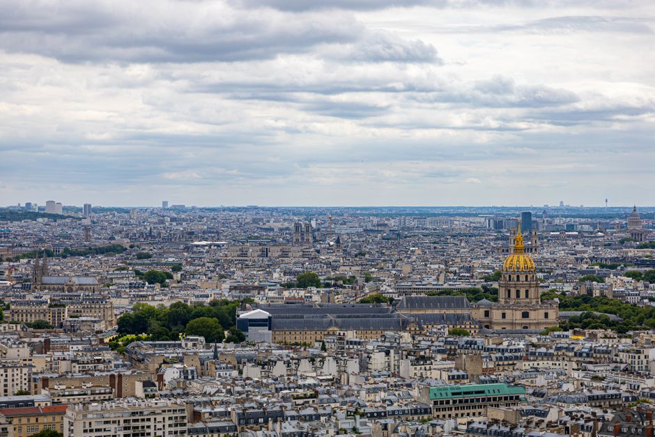 Stunning aerial view of Paris skyline with Les Invalides prominently visible under a cloudy sky.