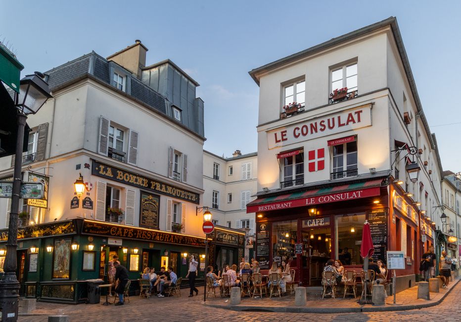 Scenic view of bustling outdoor cafés in Montmartre, Paris, capturing Parisian nightlife charm.
