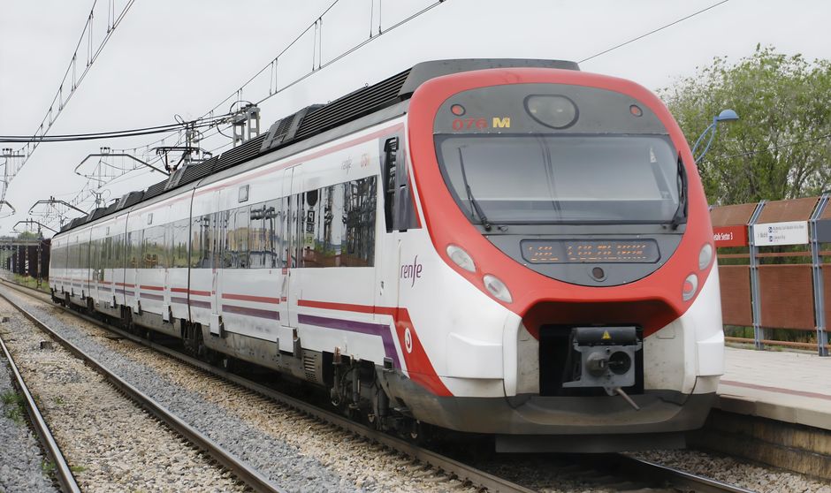 A sleek commuter train arrives at a Madrid station, showcasing modern transportation.