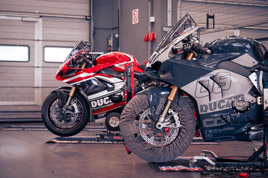 Two Ducati motorcycles in a garage at Nürburgring, perfect for racing enthusiasts.