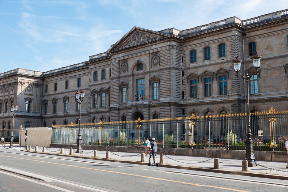 The iconic facade of the Louvre Museum in Paris captured on a bright sunny day.