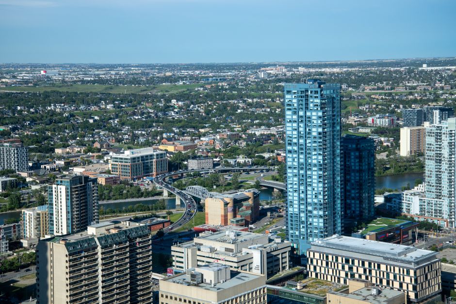 A vibrant cityscape with skyscrapers and a winding river under clear skies.