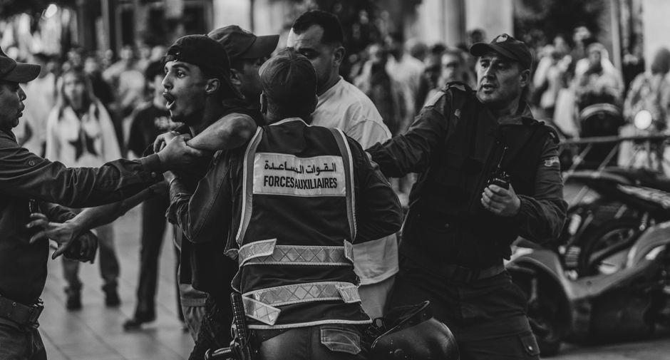 A tense street scene involving security forces and civilians in Rabat, Morocco.