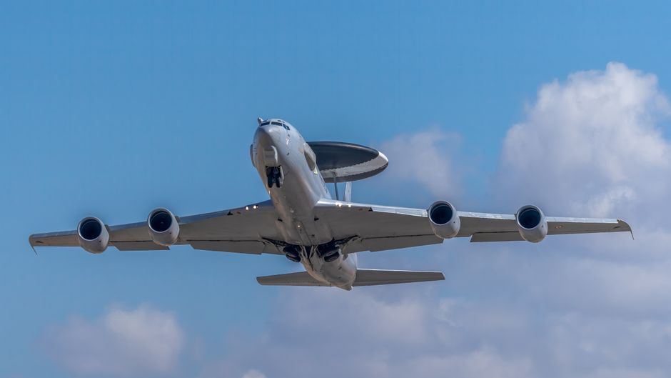 A large surveillance aircraft soaring in a clear blue sky over Albacete, Spain.
