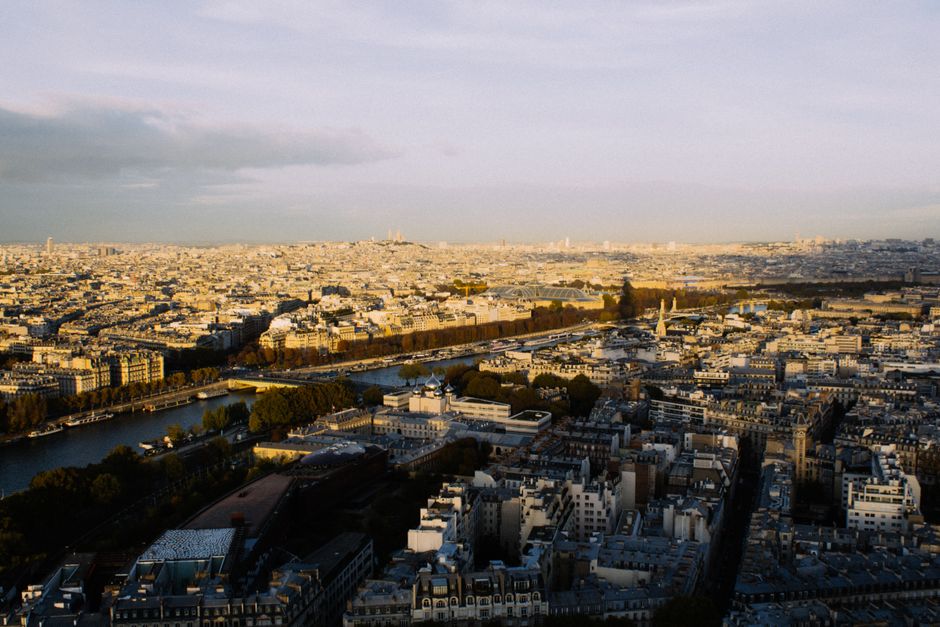 Breathtaking aerial view of Paris showcasing iconic landmarks and the Seine River at sunset.