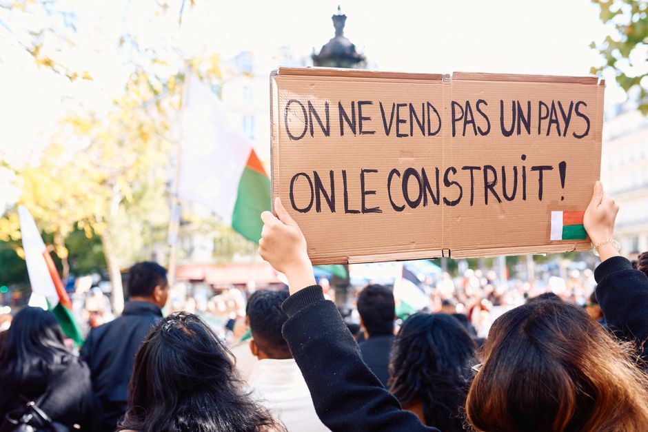 Protesters in Paris holding signs during a peaceful demonstration focusing on unity and solidarity.