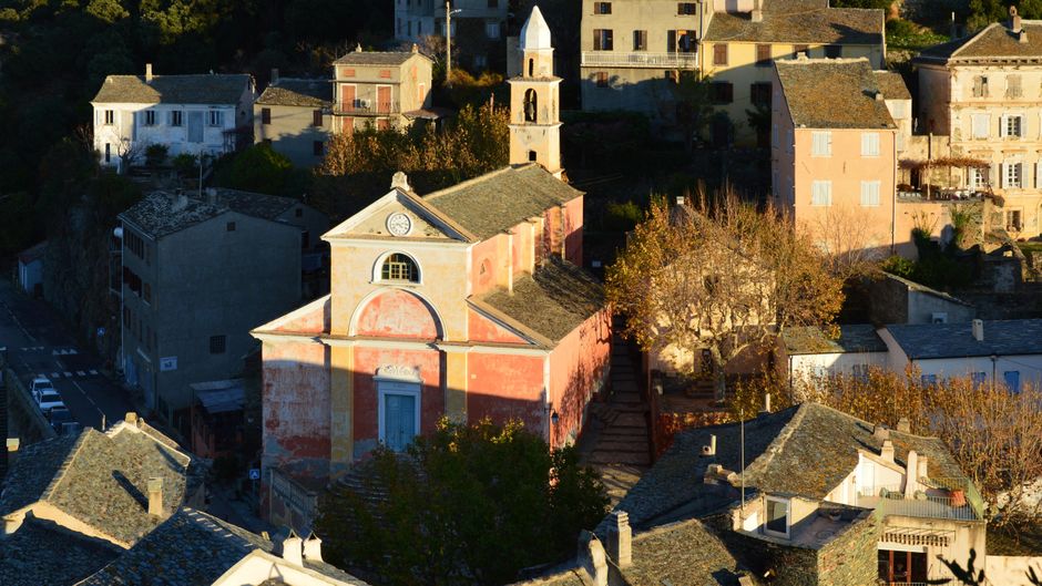 Charming aerial view of the historic church and village in Nonza, Corsica, France.