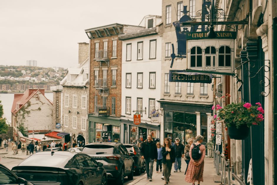 A picturesque view of a lively street in Old Québec City featuring historic buildings and tourists.