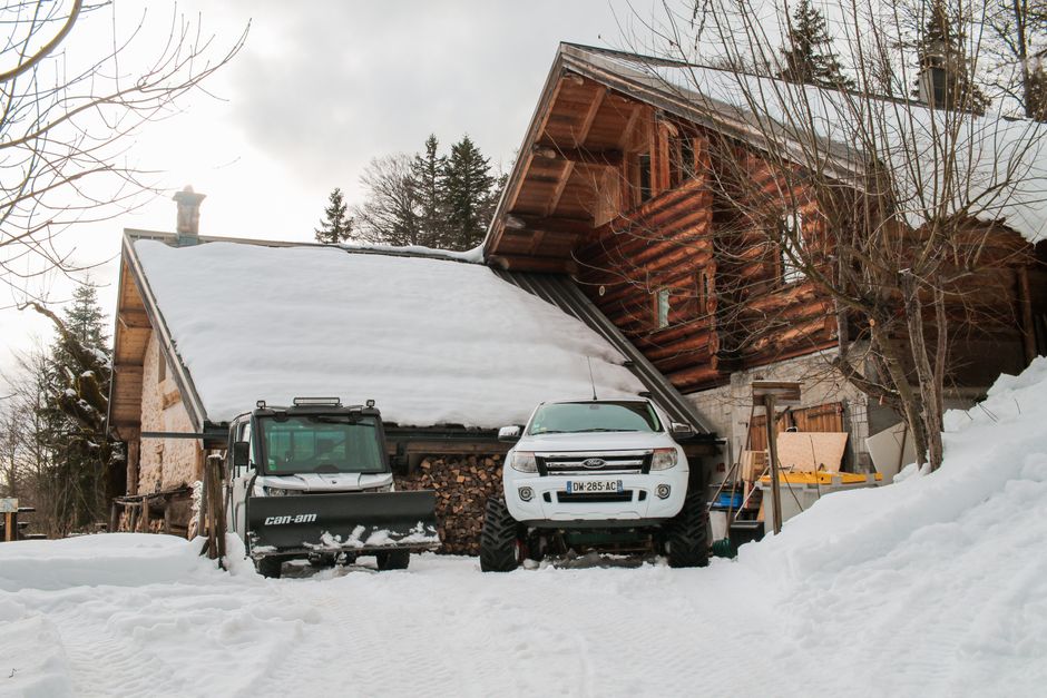 Snowy chalet in Autrans-Méaudre-en-Vercors with vehicles, capturing a serene winter scene.