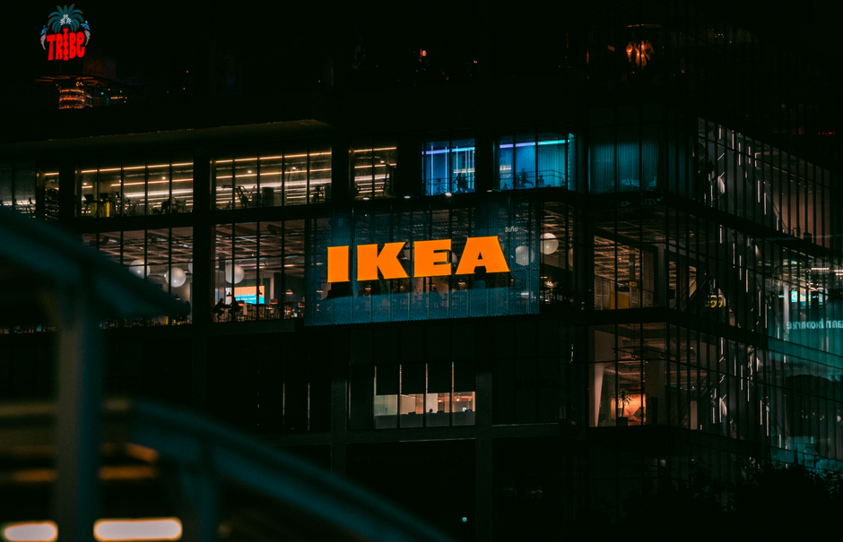 Illuminated view of an IKEA store in Bangkok at night, showcasing vibrant city lights.