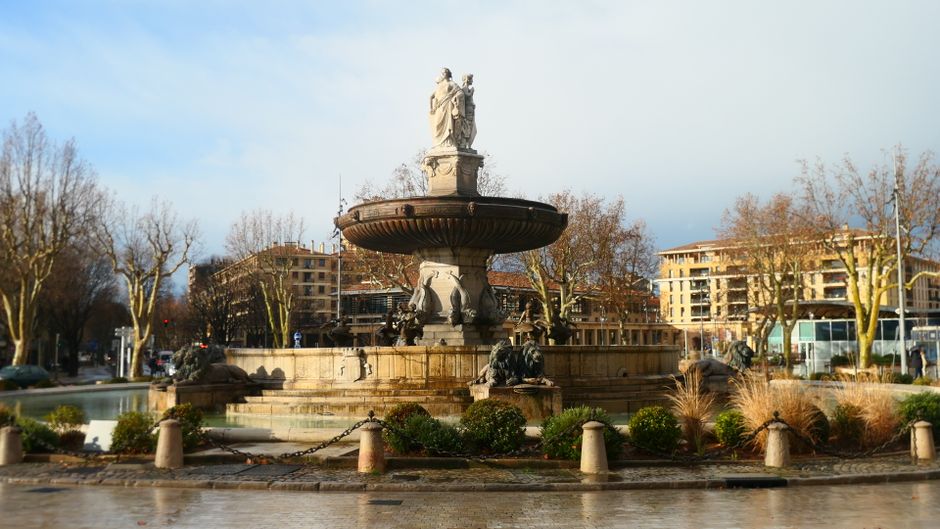 Majestic urban fountain captured in Aix-en-Provence under a bright sky.