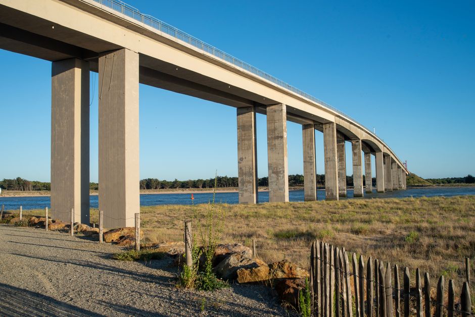 A striking image of a modern bridge spanning a waterway in Noirmoutier-en-l'Île, France, under clear blue skies.