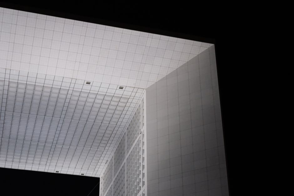 Close-up of the Grande Arche's geometric design in La Défense at night.