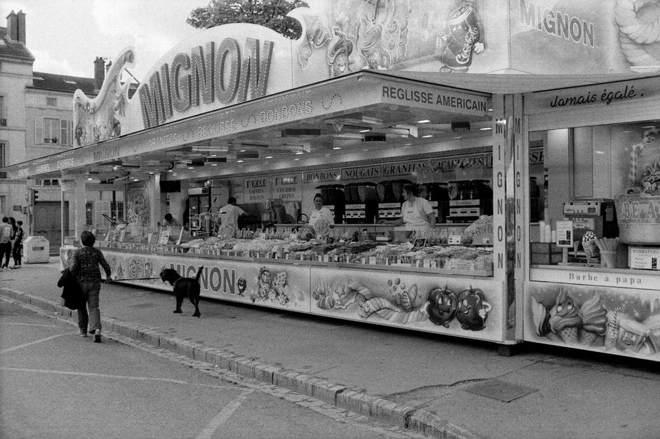 Street view of a bustling candy stall in black and white film.