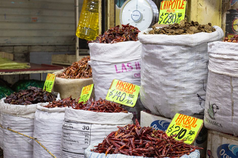 Bags of dried chilies for sale at a market in Mexico City, showcasing a colorful variety.