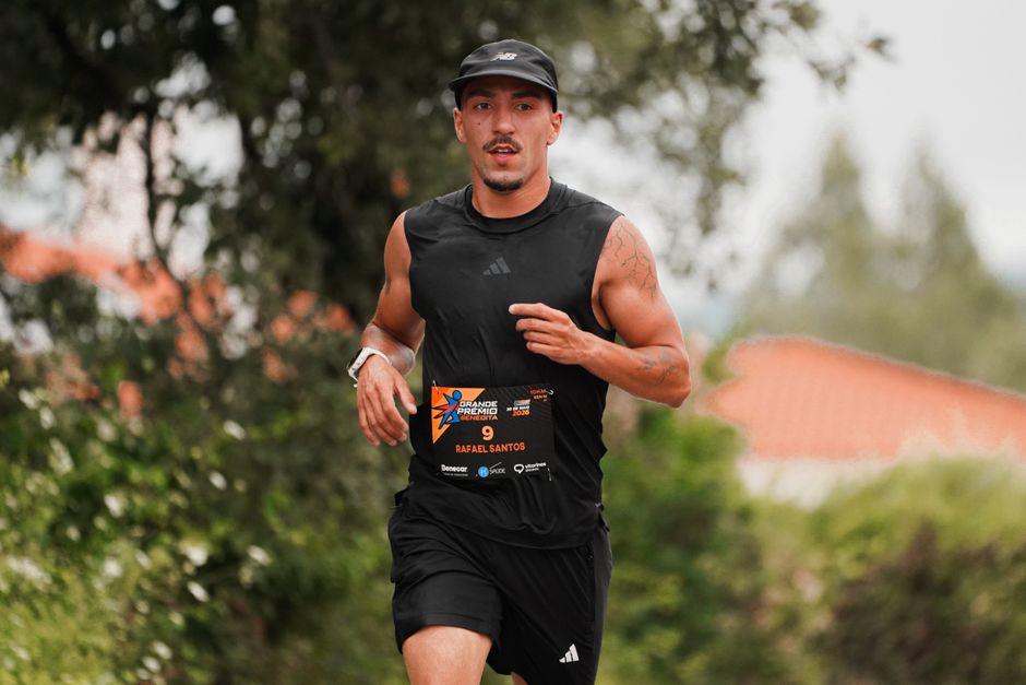 Athletic male runner participating in an outdoor marathon, wearing black sportswear.