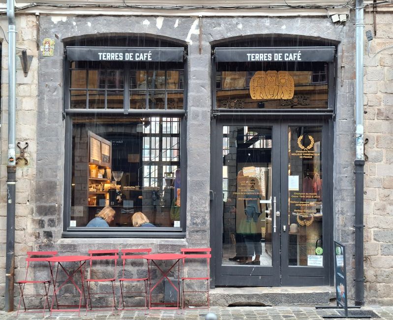 Rustic café facade with red chairs in historic Old Lille street, France.