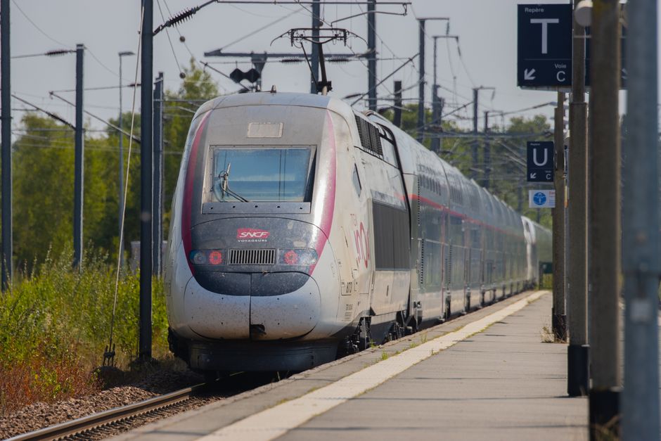 High-speed train arriving at a rural station in Dol-de-Bretagne, Brittany, France.