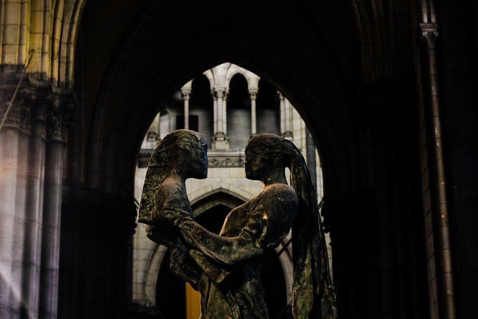Sculpture of two figures embracing inside a gothic cathedral in Lille, France.
