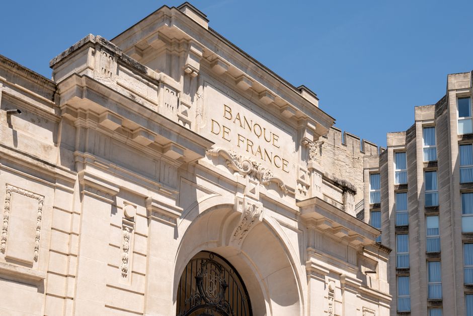 Elegant architectural facade of Banque de France in Avignon against clear blue sky.