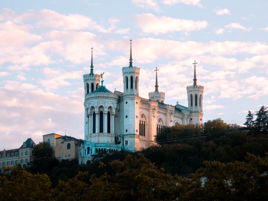 A stunning view of the Basilica of Notre-Dame de Fourvière in Lyon, France, during sunset.