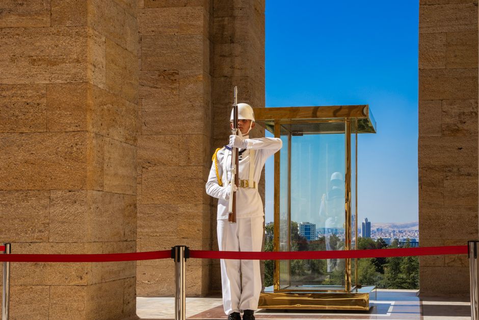 Turkish soldier standing guard at Anıtkabir in Ankara under a clear sky.