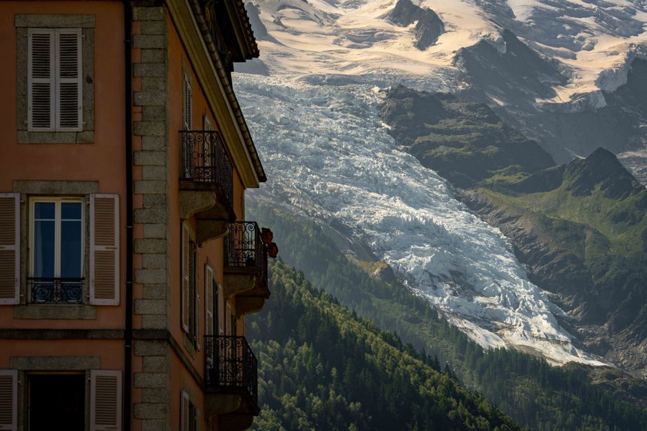 A picturesque village scene juxtaposed with stunning glacier-covered mountains in Chamonix, France.