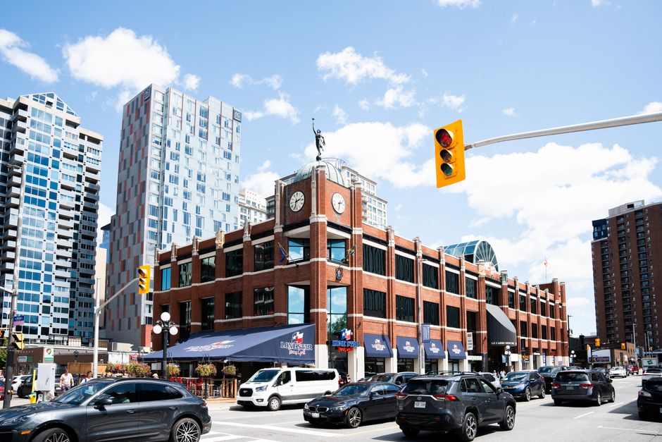 Street view of ByWard Market with traffic and modern buildings in downtown Ottawa, Canada.