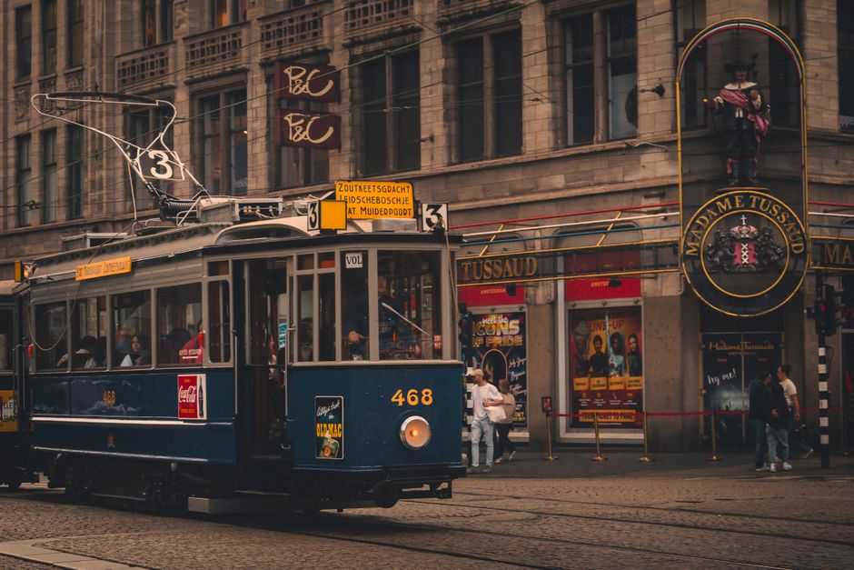 A vintage tram passing by Madame Tussaud in Amsterdã, capturing the charm of Holland's capital.