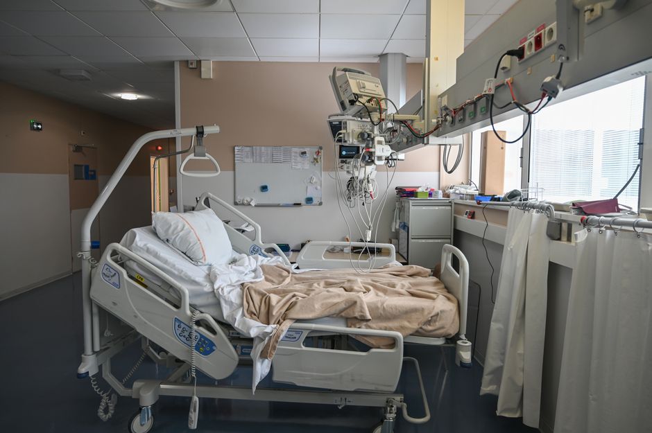 An empty hospital room with a bed and medical equipment, ideal for healthcare themes.