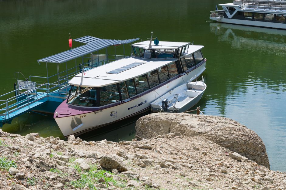 Explore the serene surroundings of a river in France with a modern tour boat docked at the shore.